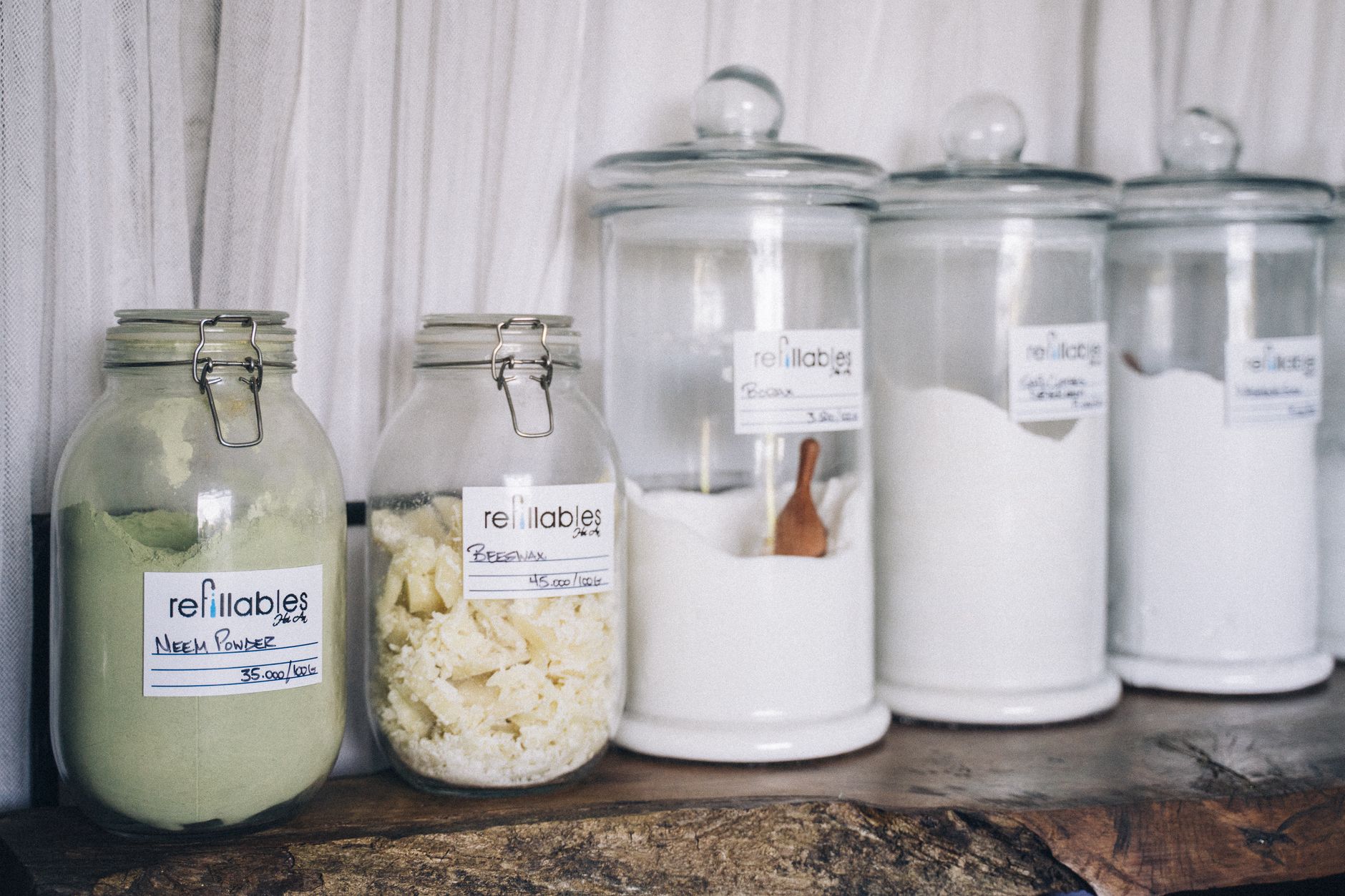 Assorted refillable glass jars containing organic products on display.