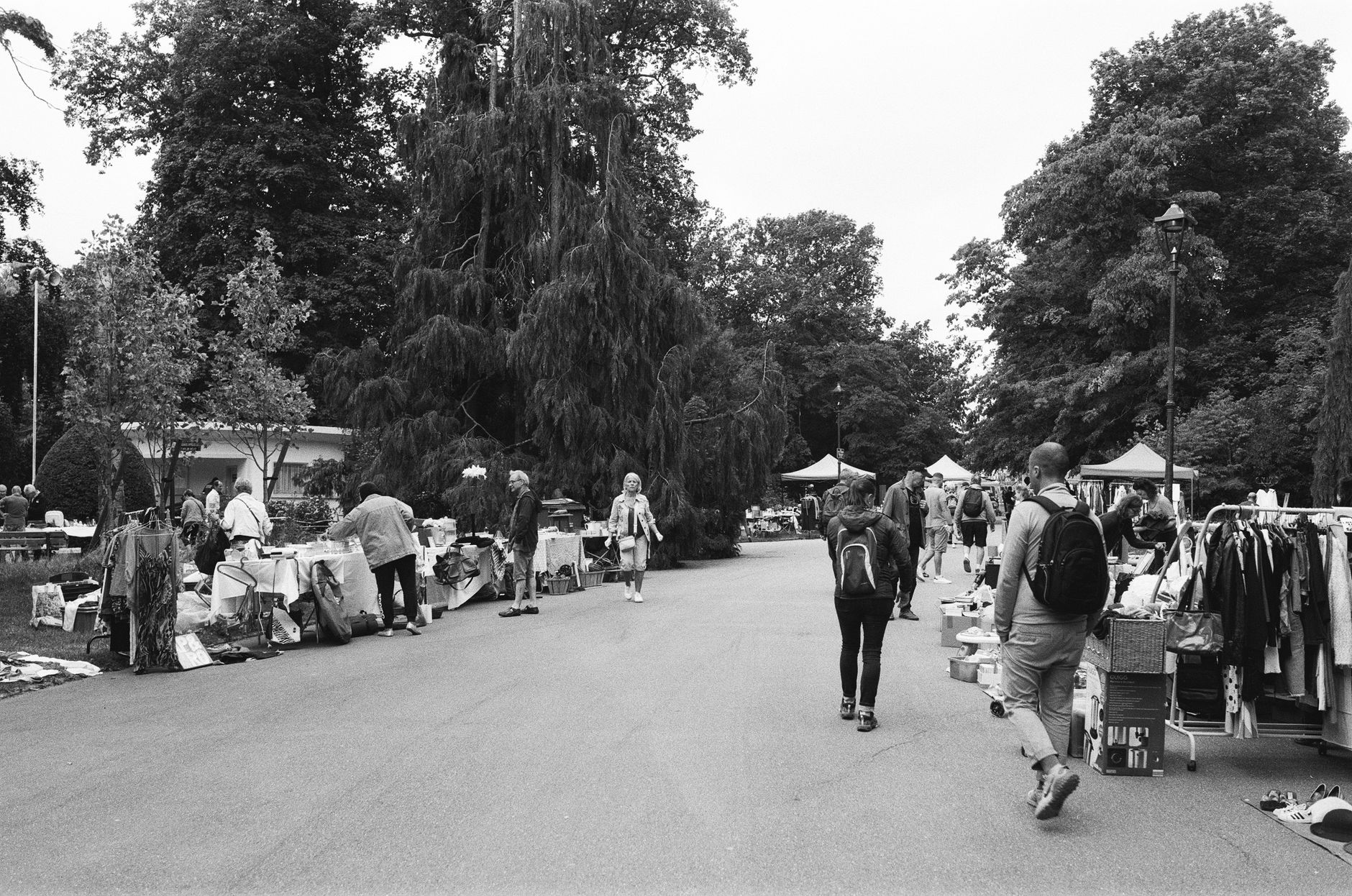 Black and white scene of a bustling outdoor market in Nancy, France, with people and stalls lining the street.