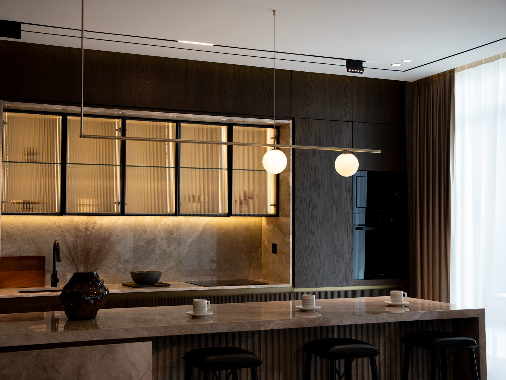 A sleek and contemporary kitchen with minimalist decor and modern lighting.