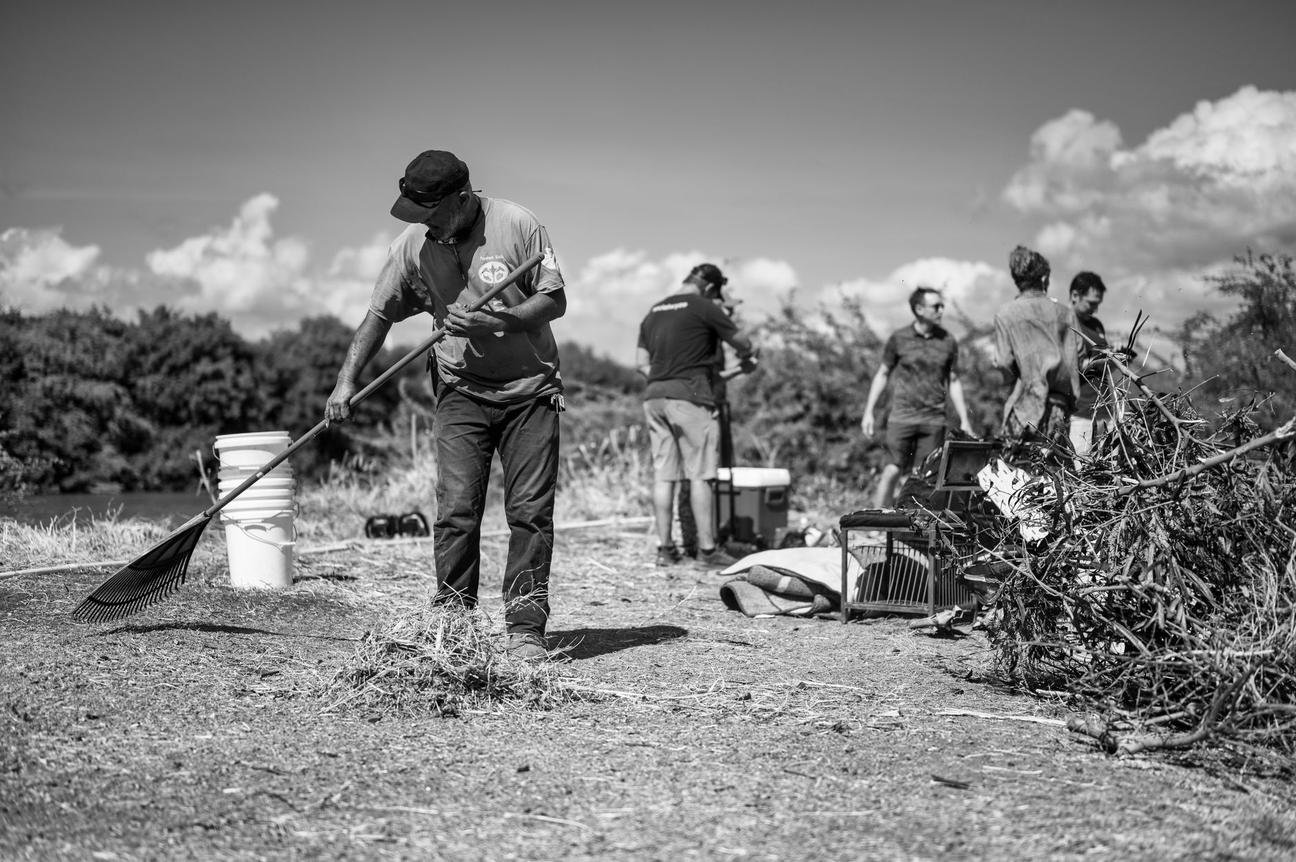A group of volunteers engaging in environmental cleanup near a river.